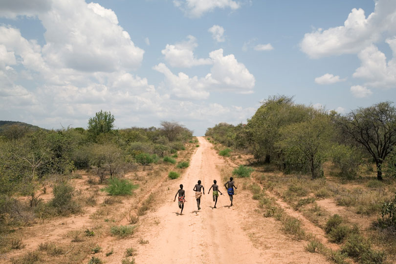 Four boys running down Dirt Road, Omo Valley, Ethiopia. © Andrew Geiger